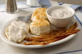 Creamy gravy over soft biscuits with a side of sausage